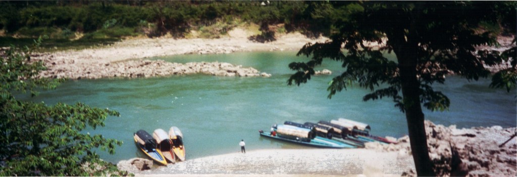 View of the Usumacinta River mooring bank at Yaschilan with several boats docked along the shore.